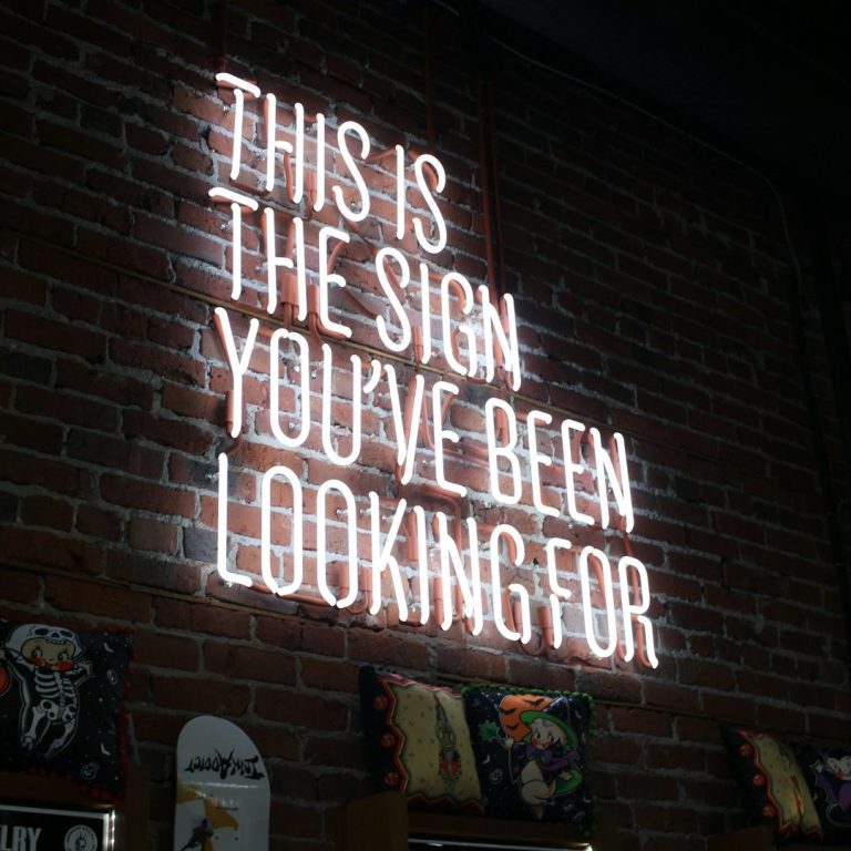 Neon-Schild an einer Ziegelwand mit der Aufschrift: "Das ist das Zeichen, nach dem du gesucht hast."